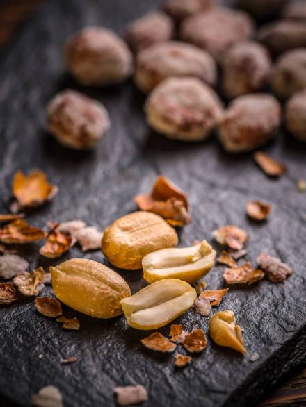 Close up of salted peanuts on black slate